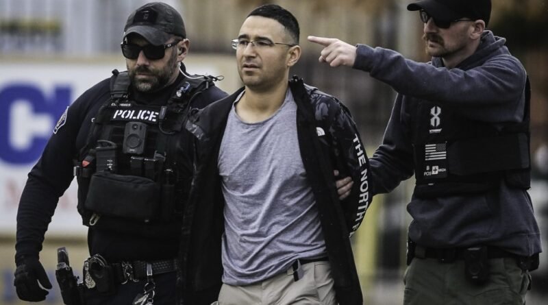 Former Republican candidate arrested in shootings targeting Democratic politicians’ homes - The suspect with hands behind his back, escorted by police officers with impressive facial hair and sunglasses.